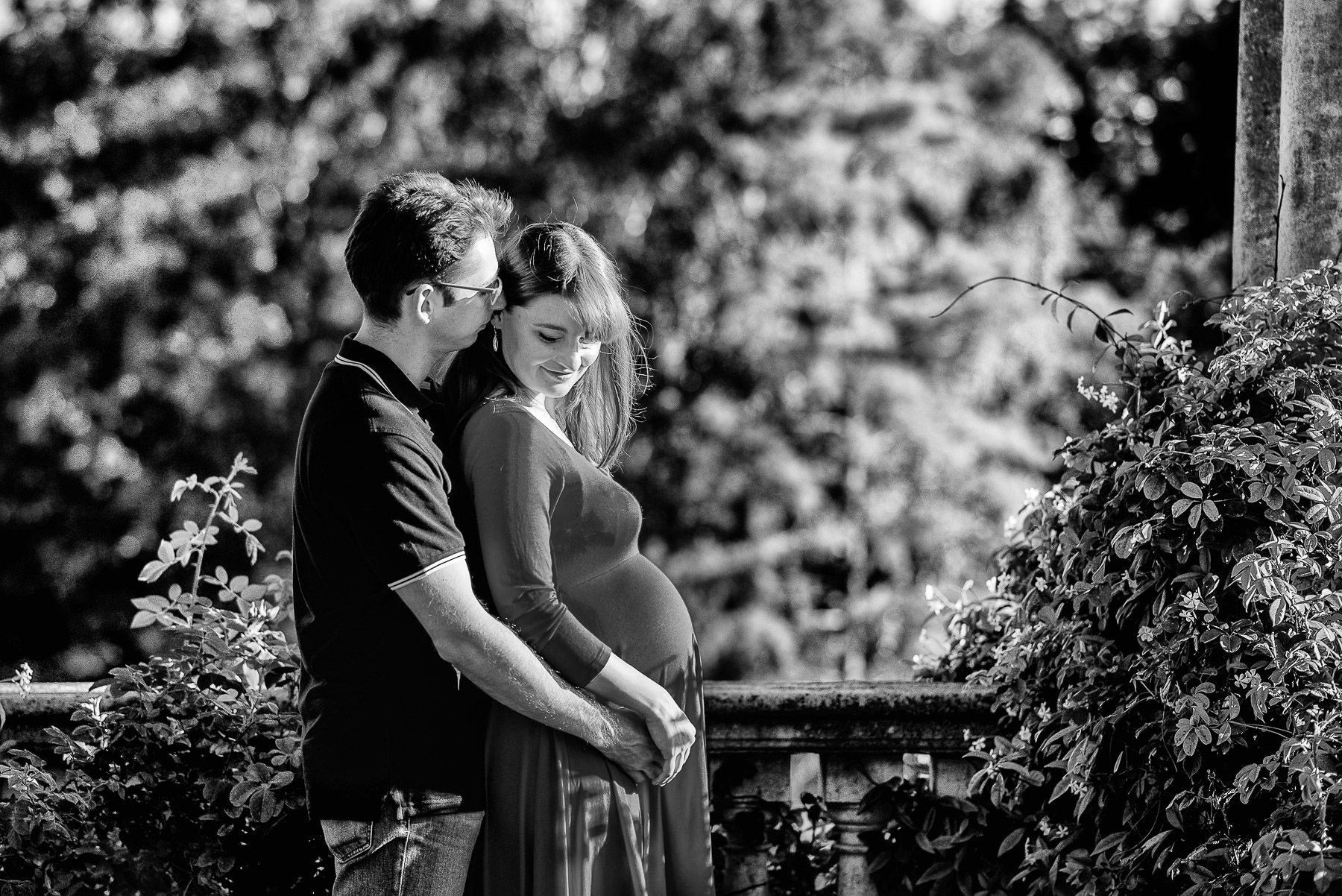 couple hugging end embracing the baby bump